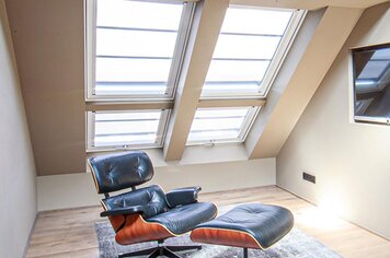 Ein Zimmer mit 4 Dachfenstern. Zwei kann man öffnen und zwei sind Blendrahmen Fenster. Alle haben eine transparente Markise.